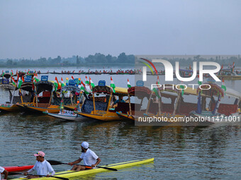 Men are rowing boats as they take part in the Tiranga Rally ahead of India's Independence Day celebrations in Srinagar, Jammu and Kashmir, o...