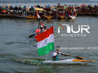 A man is riding a kayak as he takes part in the Tiranga Rally ahead of India's Independence Day celebrations in Srinagar, Jammu and Kashmir,...