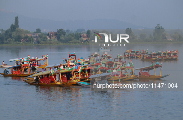 Men are rowing boats as they take part in the Tiranga Rally ahead of India's Independence Day celebrations in Srinagar, Jammu and Kashmir, o...