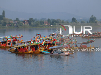 Men are rowing boats as they take part in the Tiranga Rally ahead of India's Independence Day celebrations in Srinagar, Jammu and Kashmir, o...