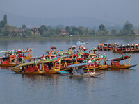 Men are rowing boats as they take part in the Tiranga Rally ahead of India's Independence Day celebrations in Srinagar, Jammu and Kashmir, o...