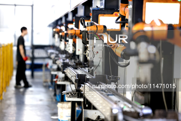 A robot is producing pump products on a production line in Ningde, Fujian province, China, on August 12, 2024. 