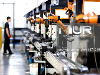 A robot is producing pump products on a production line in Ningde, Fujian province, China, on August 12, 2024. (