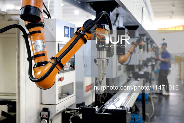 A robot is producing pump products on a production line in Ningde, Fujian province, China, on August 12, 2024. 