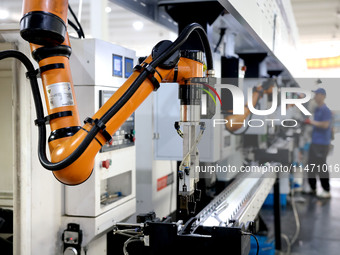 A robot is producing pump products on a production line in Ningde, Fujian province, China, on August 12, 2024. (