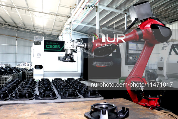 A robot is producing pump products on a production line in Ningde, Fujian province, China, on August 12, 2024. 