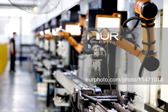 A robot is producing pump products on a production line in Ningde, Fujian province, China, on August 12, 2024. 