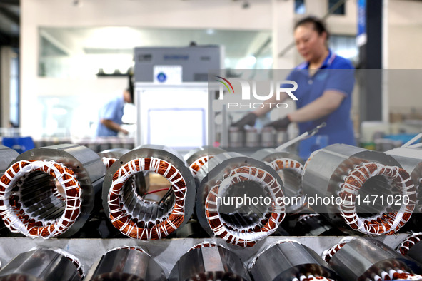 A worker is assembling water pump products at a production line in Ningde, China, on August 12, 2024. 