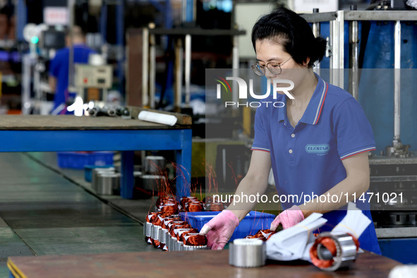 A worker is assembling water pump products at a production line in Ningde, China, on August 12, 2024. 