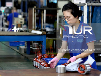 A worker is assembling water pump products at a production line in Ningde, China, on August 12, 2024. (