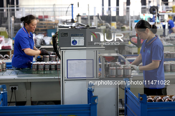 Workers are assembling water pump products at a production line in Ningde, China, on August 12, 2024. 