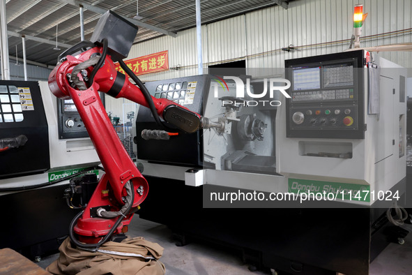 A robot is producing pump products on a production line in Ningde, Fujian province, China, on August 12, 2024. 