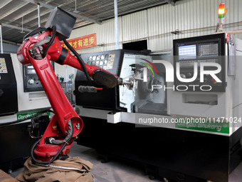 A robot is producing pump products on a production line in Ningde, Fujian province, China, on August 12, 2024. (