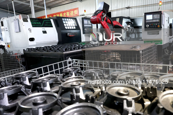 A robot is producing pump products on a production line in Ningde, Fujian province, China, on August 12, 2024. 