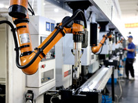 A robot is producing pump products on a production line in Ningde, Fujian province, China, on August 12, 2024. (