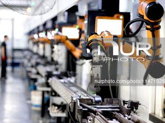 A robot is producing pump products on a production line in Ningde, Fujian province, China, on August 12, 2024. (