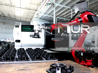 A robot is producing pump products on a production line in Ningde, Fujian province, China, on August 12, 2024. (