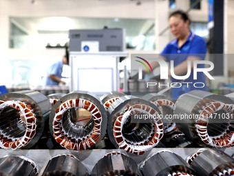 A worker is assembling water pump products at a production line in Ningde, China, on August 12, 2024. (