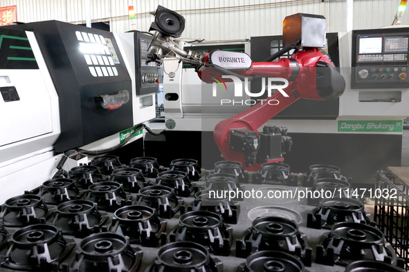 A robot is producing pump products on a production line in Ningde, Fujian province, China, on August 12, 2024. 