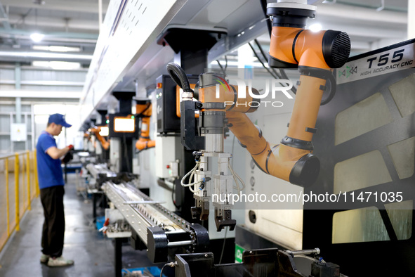 A robot is producing pump products on a production line in Ningde, Fujian province, China, on August 12, 2024. 