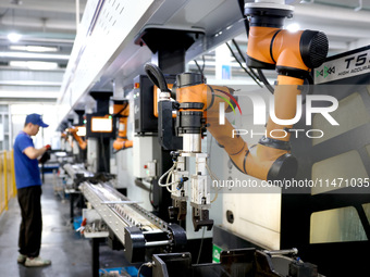 A robot is producing pump products on a production line in Ningde, Fujian province, China, on August 12, 2024. (