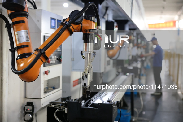 A robot is producing pump products on a production line in Ningde, Fujian province, China, on August 12, 2024. 