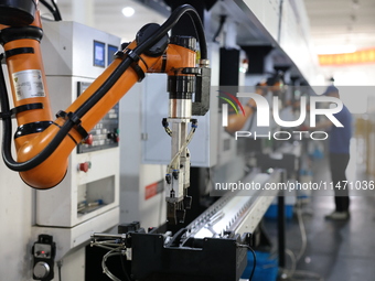 A robot is producing pump products on a production line in Ningde, Fujian province, China, on August 12, 2024. (