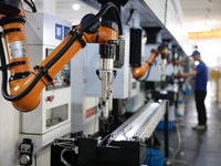 A robot is producing pump products on a production line in Ningde, Fujian province, China, on August 12, 2024. (