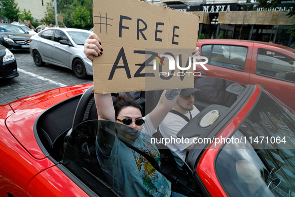 A demonstrator is holding a placard in a convertible during the Don't Be Silent. Captivity Kills! rally to support Ukrainian prisoners of wa...