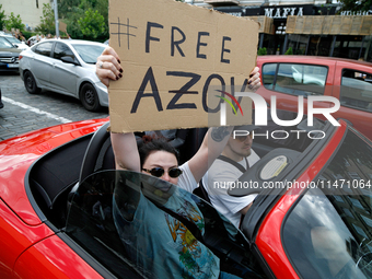 A demonstrator is holding a placard in a convertible during the Don't Be Silent. Captivity Kills! rally to support Ukrainian prisoners of wa...