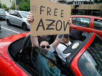 A demonstrator is holding a placard in a convertible during the Don't Be Silent. Captivity Kills! rally to support Ukrainian prisoners of wa...