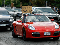 A demonstrator is holding a placard in a convertible during the Don't Be Silent. Captivity Kills! rally to support Ukrainian prisoners of wa...