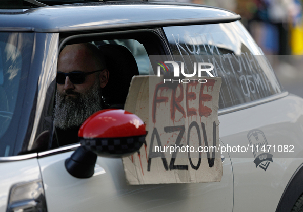 An activist is sitting in the car and holding a placard during the Don't Be Silent. Captivity Kills! rally, which is being held to support U...