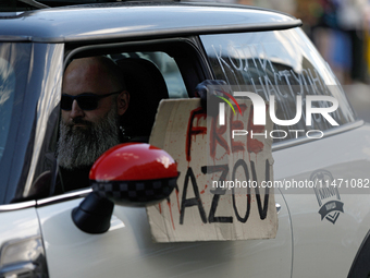 An activist is sitting in the car and holding a placard during the Don't Be Silent. Captivity Kills! rally, which is being held to support U...