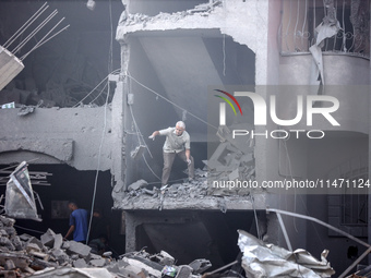 Palestinians are assessing the damage following an Israeli strike in the Nuseirat refugee camp in the central Gaza Strip on August 12, 2024,...