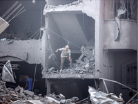 Palestinians are assessing the damage following an Israeli strike in the Nuseirat refugee camp in the central Gaza Strip on August 12, 2024,...