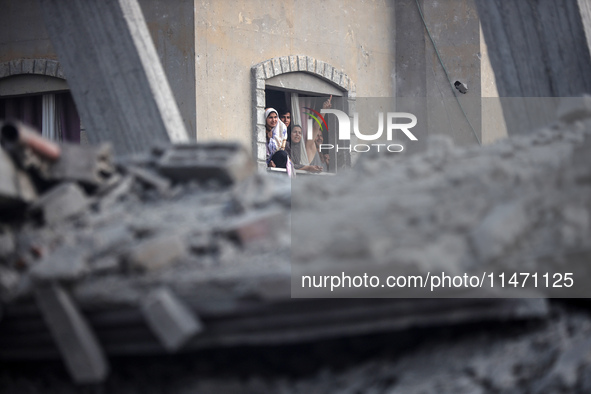 Palestinians are looking at a damaged house after an Israeli airstrike in Nuseirat, central Gaza Strip, on August 12, 2024, amid the ongoing...