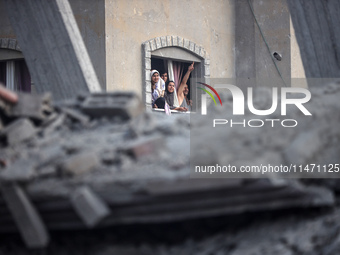 Palestinians are looking at a damaged house after an Israeli airstrike in Nuseirat, central Gaza Strip, on August 12, 2024, amid the ongoing...