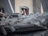 Palestinians are looking at a damaged house after an Israeli airstrike in Nuseirat, central Gaza Strip, on August 12, 2024, amid the ongoing...