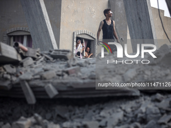 Palestinians are looking at a damaged house after an Israeli airstrike in Nuseirat, central Gaza Strip, on August 12, 2024, amid the ongoing...