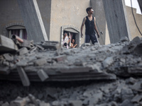 Palestinians are looking at a damaged house after an Israeli airstrike in Nuseirat, central Gaza Strip, on August 12, 2024, amid the ongoing...