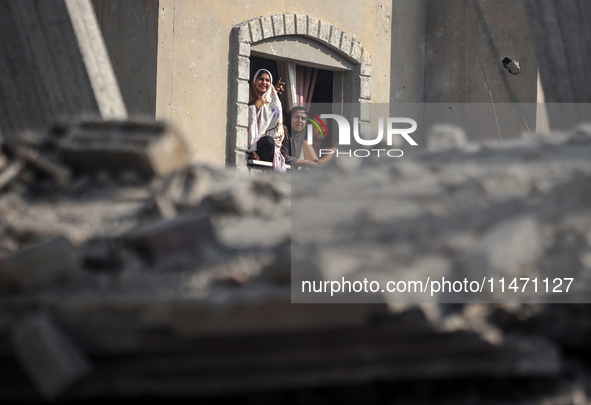 Palestinians are looking at a damaged house after an Israeli airstrike in Nuseirat, central Gaza Strip, on August 12, 2024, amid the ongoing...