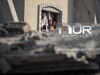 Palestinians are looking at a damaged house after an Israeli airstrike in Nuseirat, central Gaza Strip, on August 12, 2024, amid the ongoing...