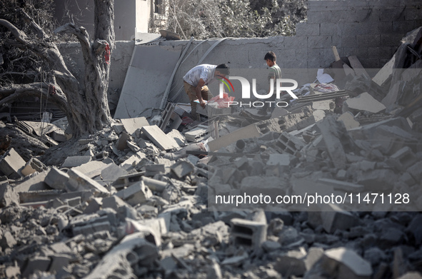 Palestinians are assessing the damage following an Israeli strike in the Nuseirat refugee camp in the central Gaza Strip on August 12, 2024,...