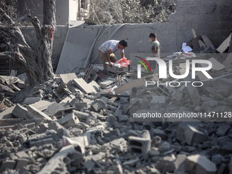 Palestinians are assessing the damage following an Israeli strike in the Nuseirat refugee camp in the central Gaza Strip on August 12, 2024,...