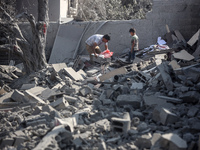 Palestinians are assessing the damage following an Israeli strike in the Nuseirat refugee camp in the central Gaza Strip on August 12, 2024,...