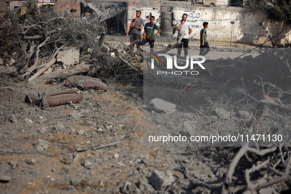 Palestinians are assessing the damage following an Israeli strike in the Nuseirat refugee camp in the central Gaza Strip on August 12, 2024,...