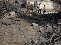 Palestinians are assessing the damage following an Israeli strike in the Nuseirat refugee camp in the central Gaza Strip on August 12, 2024,...