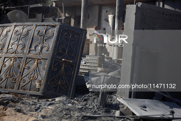 Palestinians are assessing the damage following an Israeli strike in the Nuseirat refugee camp in the central Gaza Strip on August 12, 2024,...