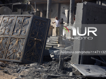 Palestinians are assessing the damage following an Israeli strike in the Nuseirat refugee camp in the central Gaza Strip on August 12, 2024,...